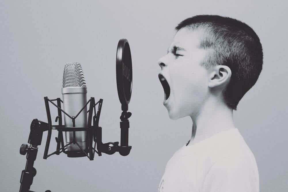 A boy who sings powerfully into a microphone